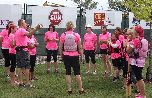 Pink Crusaders in tem circle on land getting ready for practice.