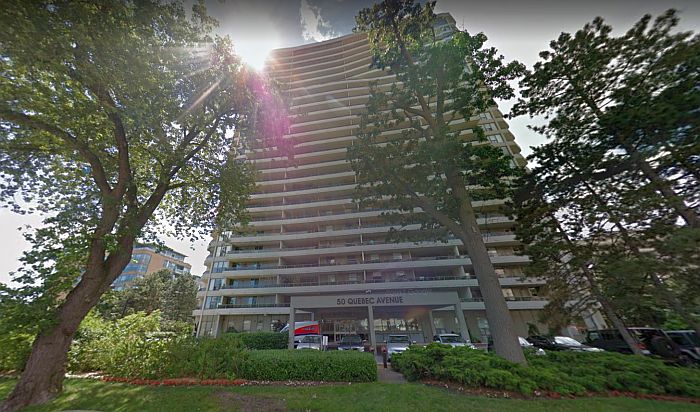 Picture of the 50 Quebec Avenue building (25 stories high with pine trees in front)